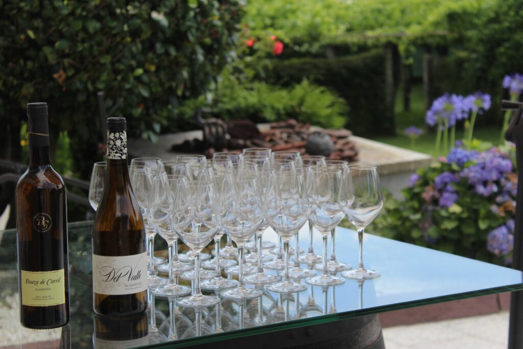 copas de vino sobre una mesa junto a varias botellas de vino Bouza de carril preparados para una cata de vinos en una visita de enoturismo
